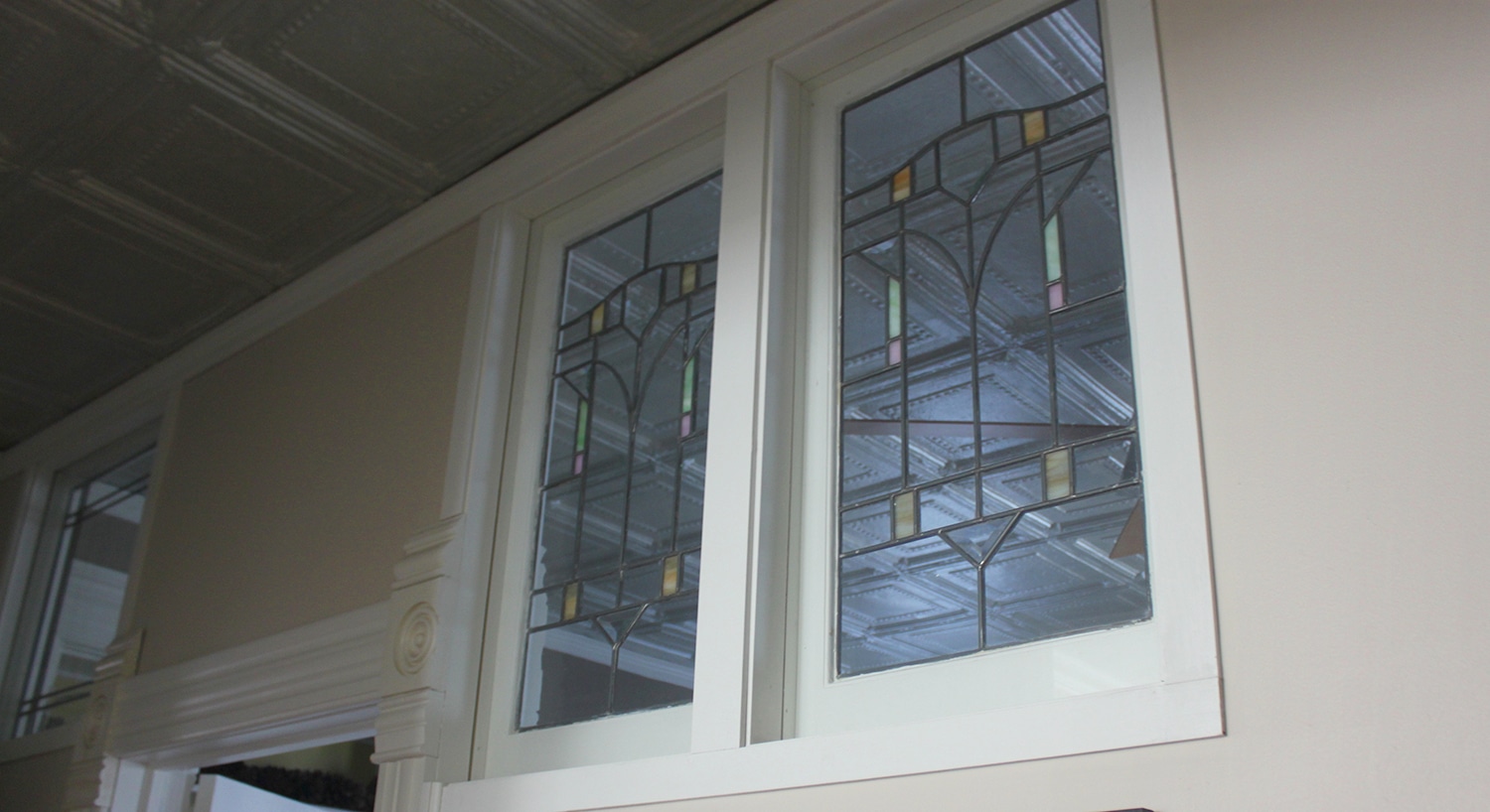 clear and colorful leaded stained glass windows in white-wood-frames.