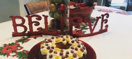 Photo of dining table with a cake and sign that reads "Believe"