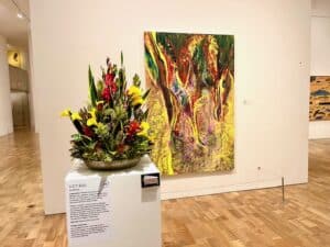 Orange floral display next to an orange painting