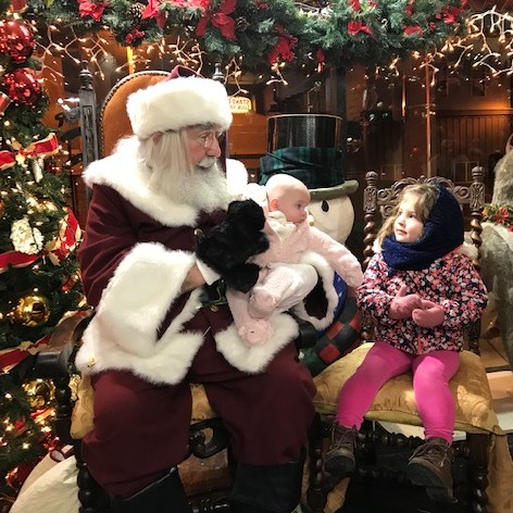 two children visiting Santa at The Brass Rooster hat shop