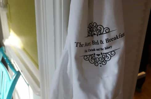 Flour sack towel hanging from wall with text: The Muse Bed & Breakfast Eat, Drink and Be Mary.