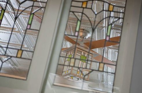 Stained glass windows in a door look out to a stained glass light fixture.