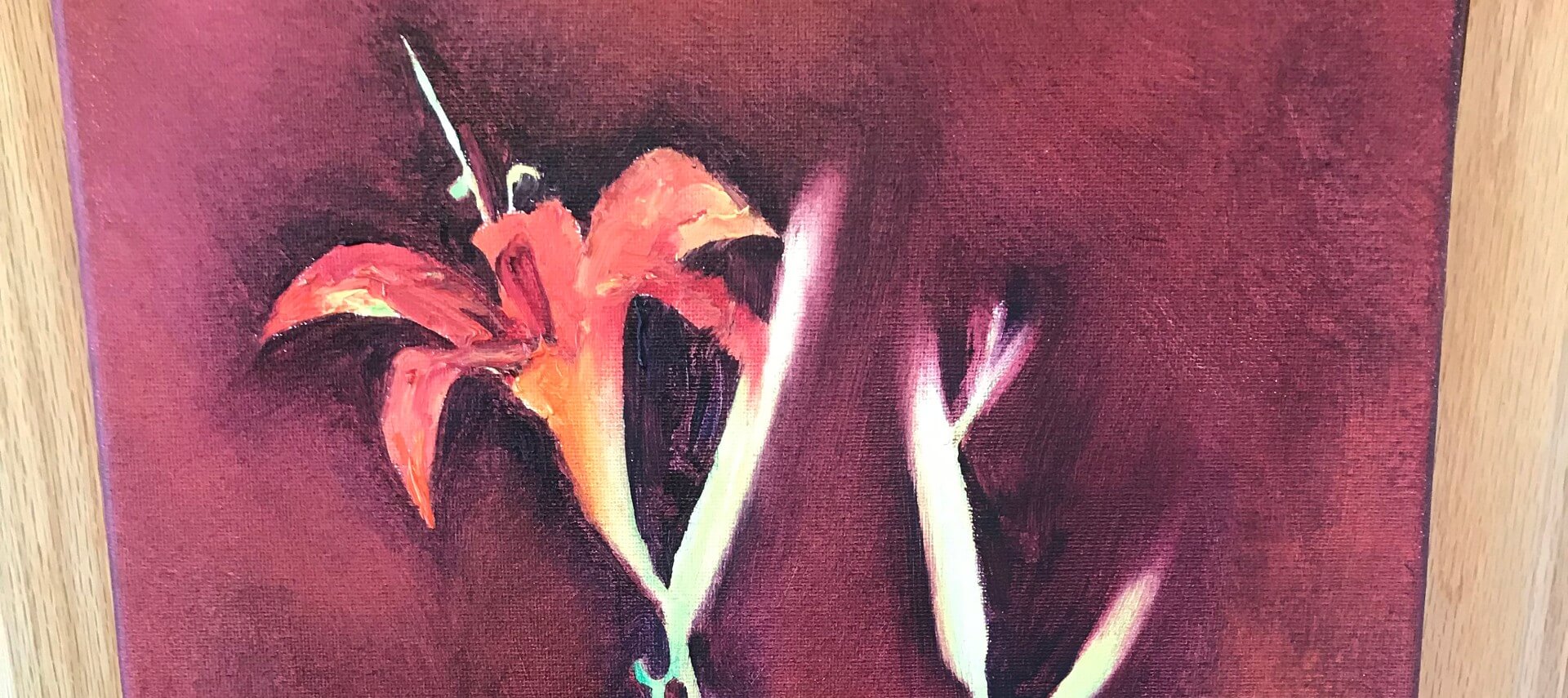 Painting of two red Irises on a burgindy background with a wooden frame.