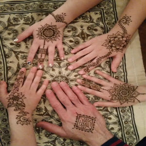 Picture of four hands with henna designs