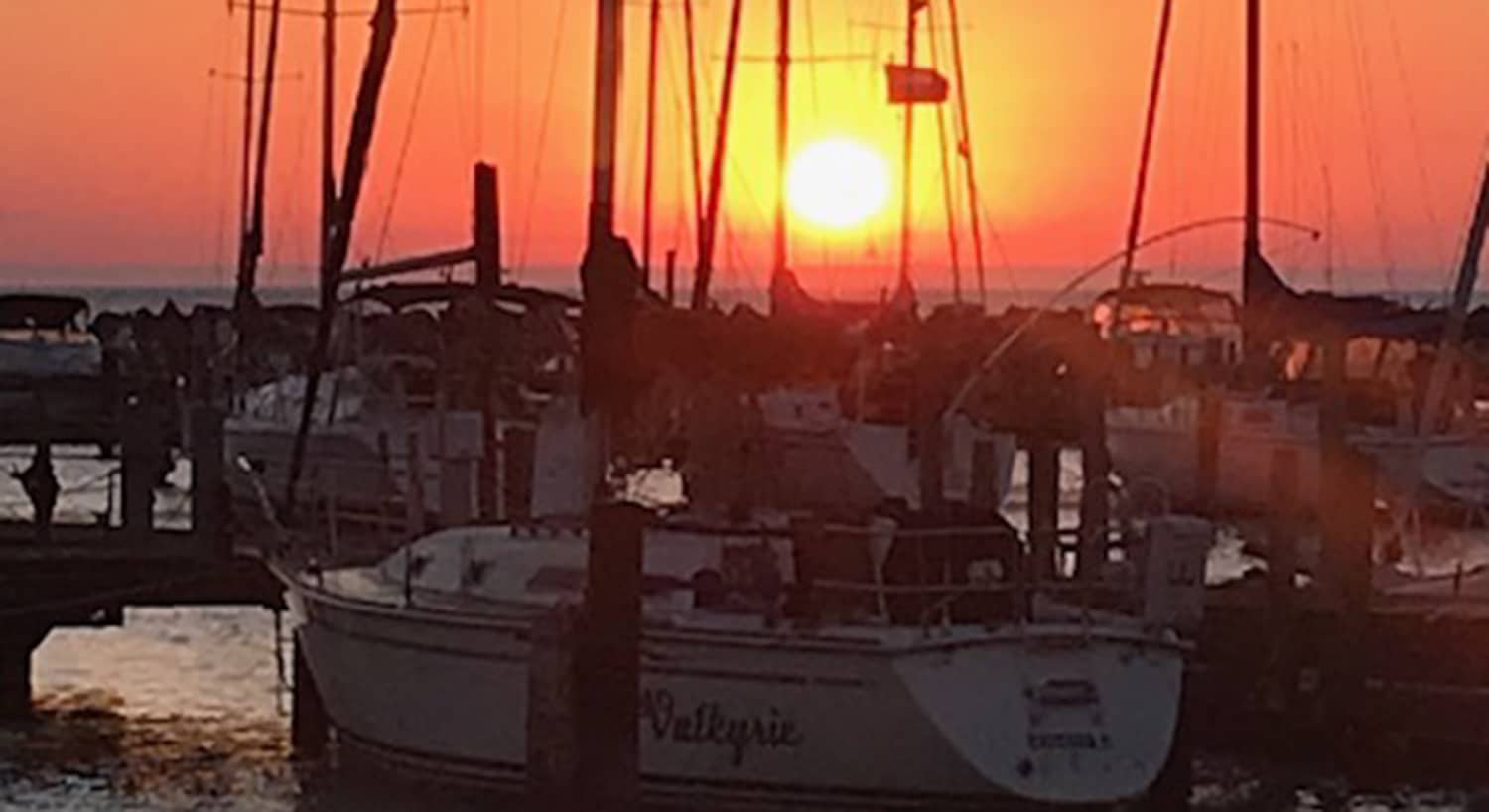 Sunset over sailboats at South Shore Yacht Club and Marina